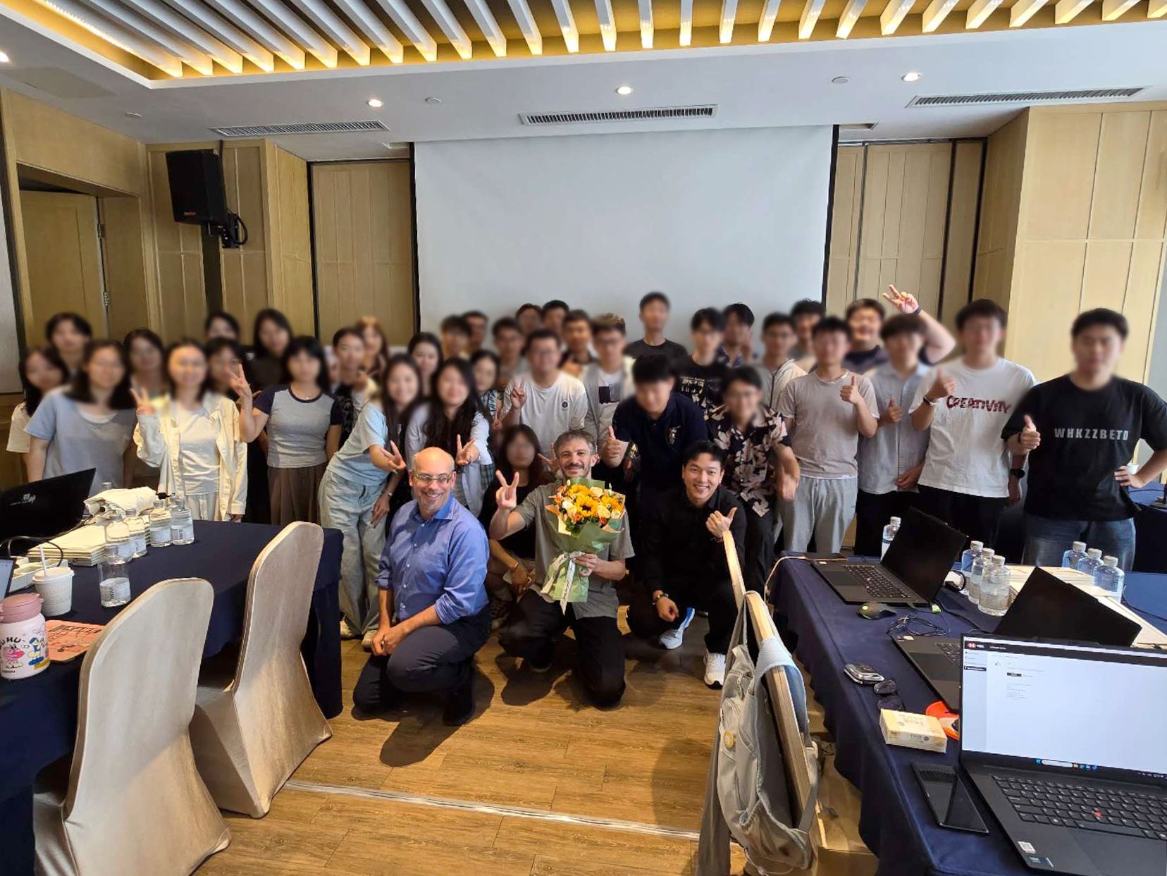Training completion ceremony in China with flowers and a large group of trainees