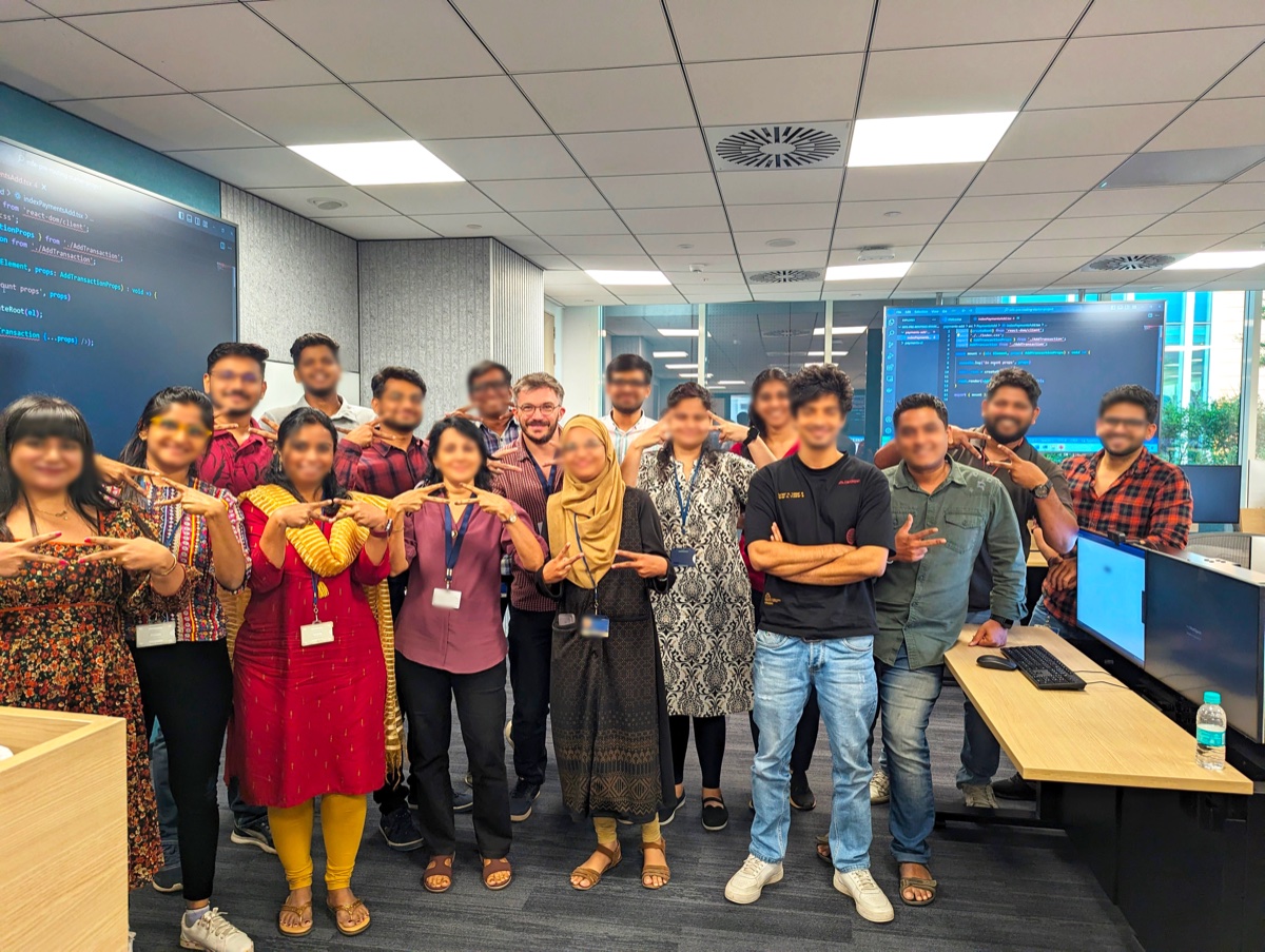 Large training group in India with code on screens